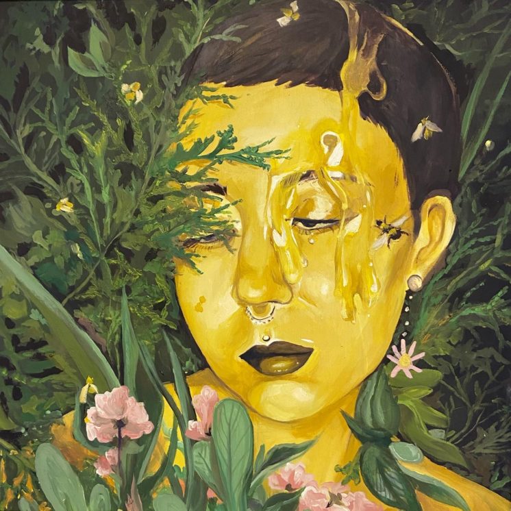 A woman painted yellow with honey dripping down her face is surrounded by bees and plants